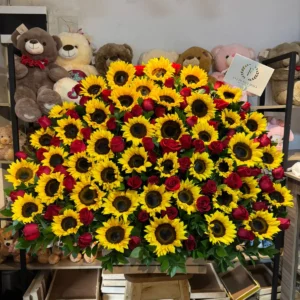 Arreglo floral en girasoles con rosas rojas