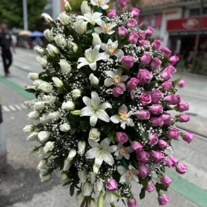 Corona funebre en rosas blancas y moradas, lirios y orquideas