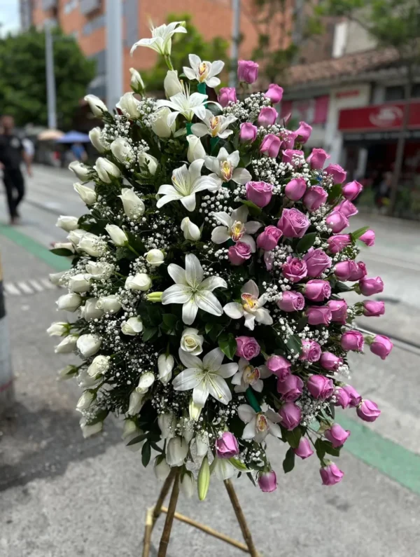 Corona funebre en rosas blancas y moradas, lirios y orquideas