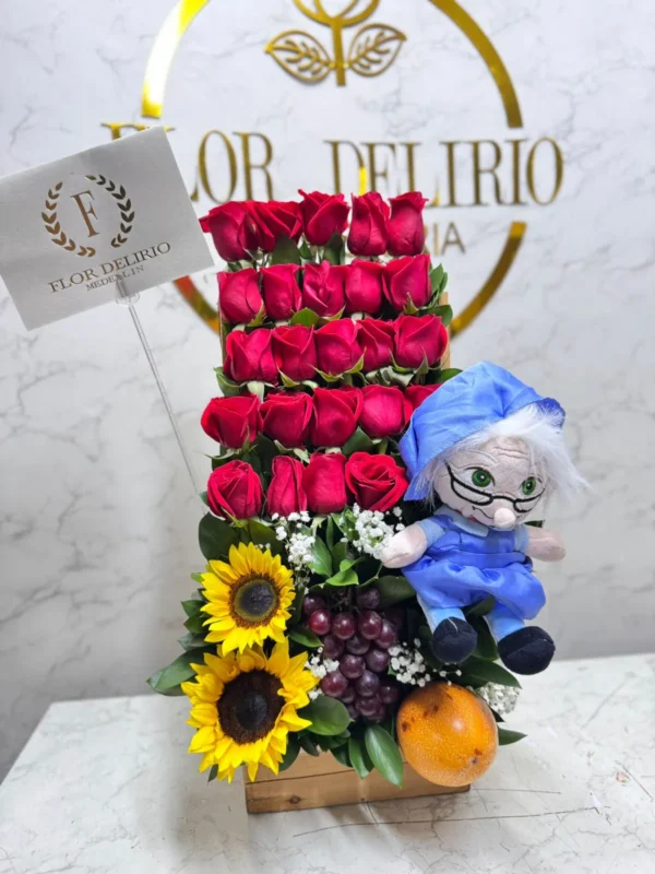 Arreglo floral con rosas, girasoles, frutas y peluche