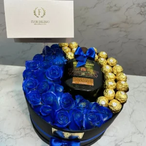 Cilindro con rosas azules, chocolates Ferrero Rocher y botella de Buchana's