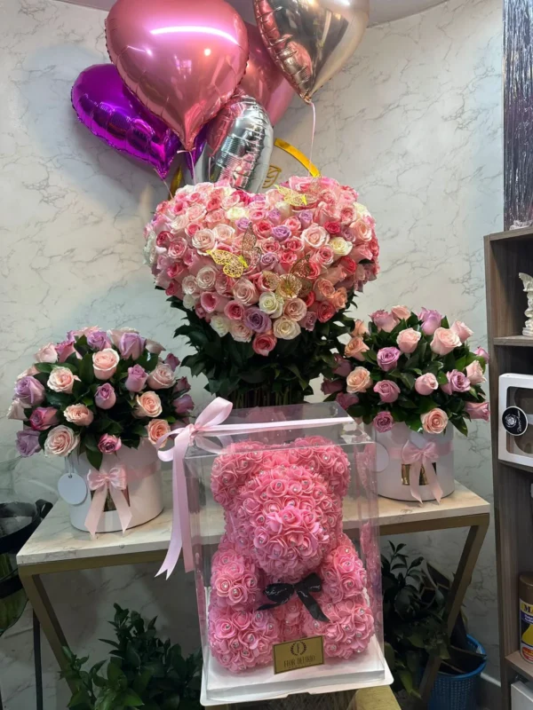 Arreglo floral corazon en rosas y globos con helio, dos cilindros en rosas y oso teddy